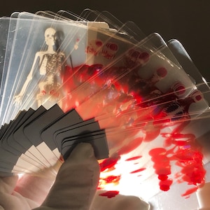 Image of Transparent Skeleton Playing Cards stacked in a neat pile next to a poker chip set and magician’s wand, conveying their use as a functional magic trick deck or science-themed poker night upgrade, combining education with entertainment and unique gifting potential.