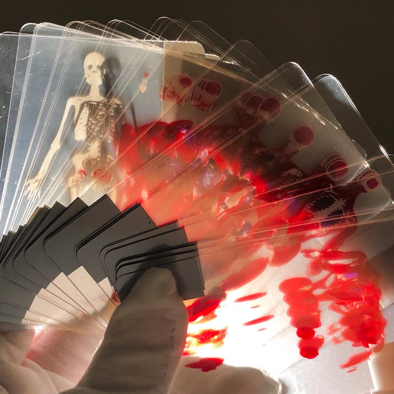 Image of Transparent Skeleton Playing Cards stacked in a neat pile next to a poker chip set and magician’s wand, conveying their use as a functional magic trick deck or science-themed poker night upgrade, combining education with entertainment and unique gifting potential.