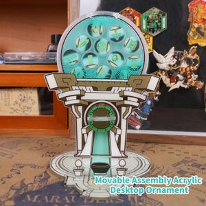 Op de afbeelding: Een decoratief acryl bureaubladornament met een teal en wit kleurenschema. Het ornament heeft een cirkelvormige bovenkant met teal ontwerpen en een gedetailleerde basis. De tekst "Movable Assembly Acrylic Desktop Ornament" is zichtbaar.