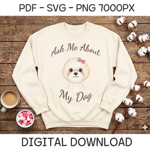 Pode incluir: Camisola creme com o texto "Ask Me About My Dog" e uma ilustração em aquarela de um cão branco fofo com um laço rosa. As palavras "DIGITAL DOWNLOAD" estão na parte inferior.