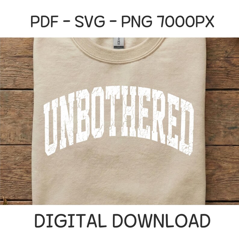 Puede incluir: Una sudadera beige con la palabra "UNBOTHERED" en letras blancas desgastadas. El texto est&aacute; arqueado en la parte delantera. Tambi&eacute;n se ven las palabras "PDF - SVG - PNG 7000PX" y "DESCARGA DIGITAL".