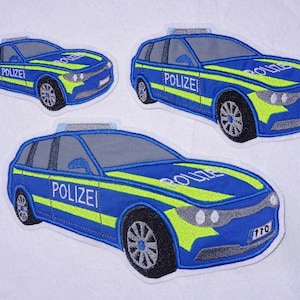 Może przedstawiać: Trzy niebieskie i żółte haftowane naszywki z niemieckimi radiowozami. Każda naszywka zawiera napis "Polizei" i numer "110".