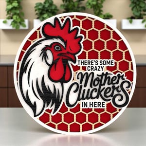 May include: A round, layered wooden sign featuring a rooster head with red comb and wattle, and the text "THERE'S SOME CRAZY Mother Cluckers IN HERE" in black script. The background is red with a honeycomb pattern.