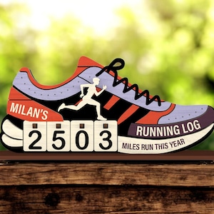 May include: A wooden running shoe-shaped sign with the text "MILAN'S" and "RUNNING LOG". The sign displays the number "2503" on a counter and features a runner silhouette. The shoe design incorporates red, black, and purple accents.