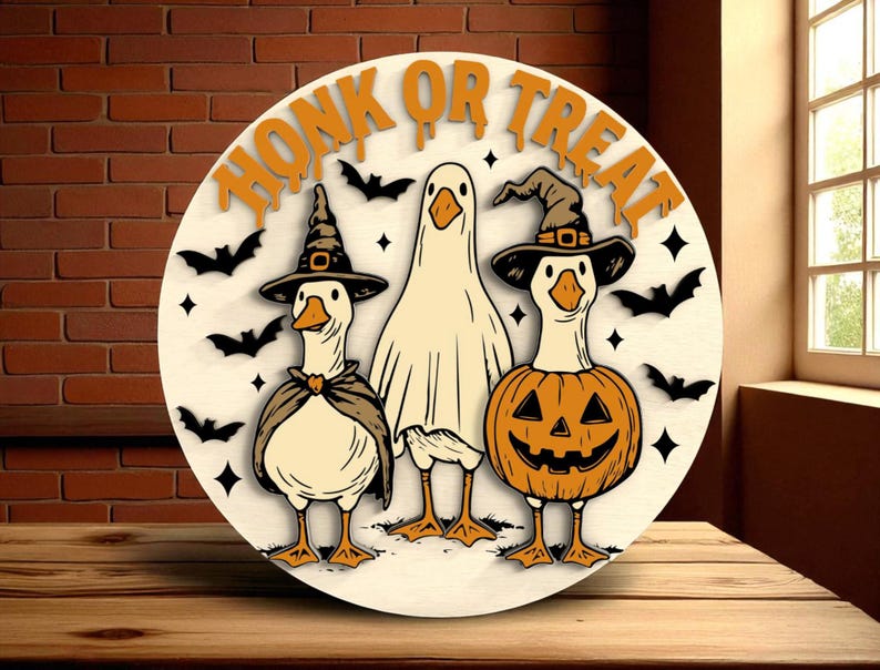 Puede incluir: Decoraci&oacute;n redonda de Halloween de madera con tres gansos de dibujos animados. Uno est&aacute; disfrazado de fantasma, otro de bruja y el tercero de calabaza. Las palabras "HONK OR TREAT" est&aacute;n en la parte superior, con murci&eacute;lagos y estrellas.