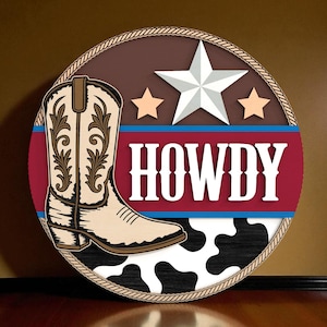 May include: Round wooden sign with a cowboy boot, star, and the word "HOWDY". The sign features a cream-colored boot with brown detailing, a white star, and two smaller stars. The background includes a cowhide pattern.