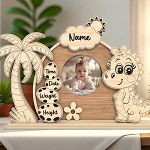 May include: Wooden photo frame with a dinosaur design. The frame has a space for a photo, a name, and spaces to record the time, date, weight, and height.