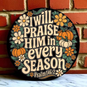 May include: A round black sign with the text "I will PRAISE HIM in EVERY SEASON" in a retro font. The sign is decorated with orange and white flowers, pumpkins, and the Bible verse Psalm 146:2.