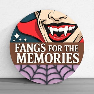 May include: A round wooden sign with a vampire graphic and the text "Fangs for the Memories." The top half features a smiling vampire with fangs, and the bottom half has a spiderweb design.
