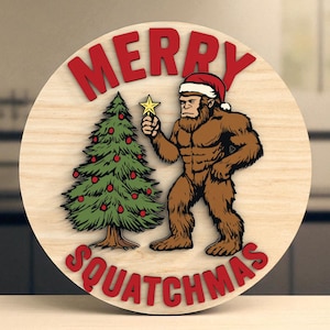 Op de afbeelding: Een ronde houten plaat met de rode tekst "MERRY SQUATCHMAS". Een bruin Bigfoot-figuur met een kerstmuts staat naast een groene kerstboom versierd met rode ballen. De Bigfoot houdt een gouden ster vast.