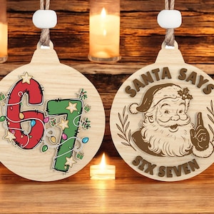 Può includere: Due decorazioni natalizie in legno. Una presenta i numeri "67" in rosso e verde con luci a stringa e stelle. L'altra decorazione ha un'immagine di Babbo Natale e il testo "SANTA SAYS SIX SEVEN". Entrambe hanno un cordino per appenderle.