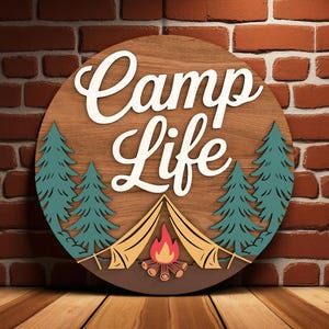 May include: A round wooden sign with the words "Camp Life" in white script. The sign features teal pine trees, a yellow tent, and a campfire. The background is a wood grain pattern.