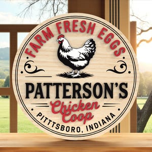 May include: A round wooden sign with the text "FARM FRESH EGGS" in red letters. The sign features a black and white illustration of a chicken and the text "PATTERSON'S Chicken Coop PITTSBORO, INDIANA".
