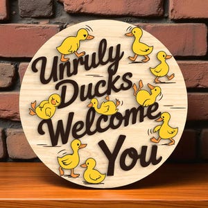 May include: A round wooden sign with the words "Unruly Ducks Welcome You" in dark brown lettering. Yellow cartoon ducks are scattered around the text. The sign is on a wooden surface with a brick background.