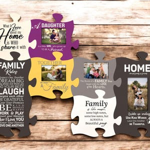 Puede incluir: Un marco de fotos de madera de varias piezas con forma de rompecabezas con texto temático familiar y espacio para fotos. El marco es en tonos de gris, blanco, amarillo y morado. El texto incluye "Family Rules" y "Home."
