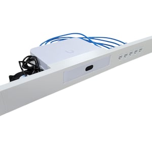 May include: A white rack-mount panel featuring a central white square access point with a small black sensor, five Ethernet ports on the right side, a black cooling fan on the left, and several blue Ethernet cables connected to the rear.