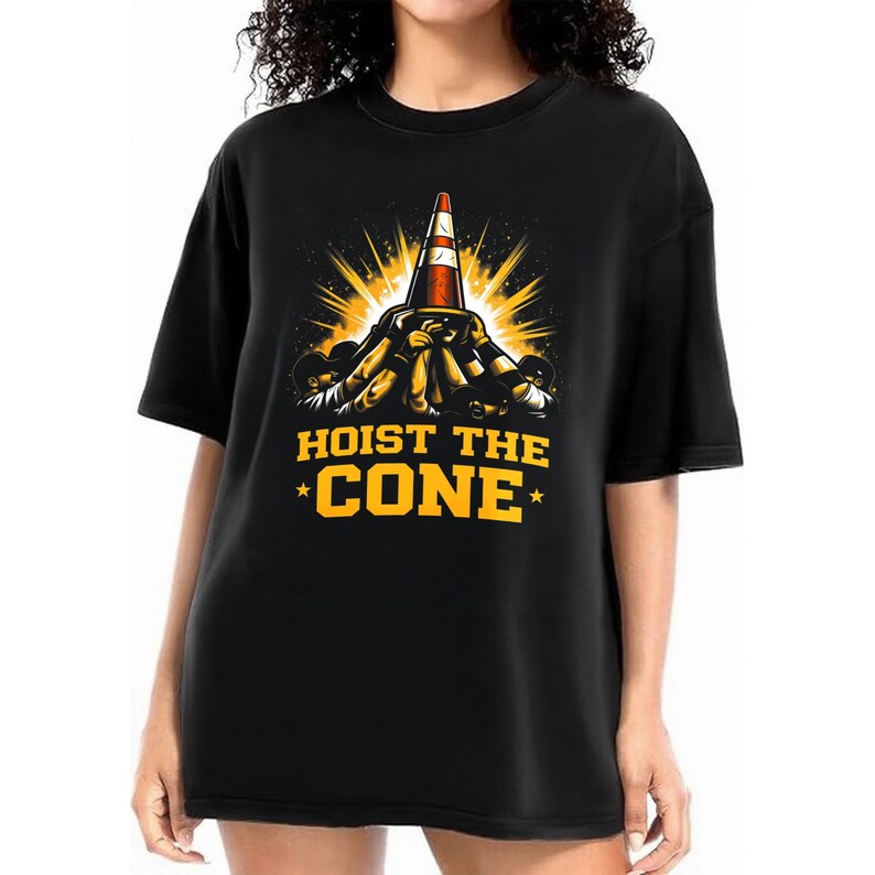 May include: Black t-shirt with a graphic of a traffic cone and the text "HOIST THE CONE" in yellow. The cone is red and white, with a burst of yellow light behind it. The design is centered on the front of the shirt.