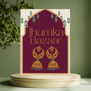 以下が含まれることがあります： 「Jhumka Bazaar」のプロモーションポスター。複雑なデザインの2つの金色のイヤリングが特徴です。ポスターは、吊り下げられたランタンが付いたバーガンディの背景で、木製の台座に表示されています。