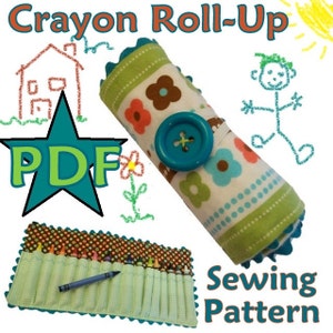 May include: A PDF sewing pattern for a crayon roll-up. The pattern includes a green, white, and brown fabric with flowers and polka dots. The finished product is a green and brown fabric roll-up with a blue button and elastic.