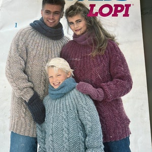 May include: A magazine cover featuring a family wearing knitted sweaters. The magazine is titled "Reynolds Lopi" and the cover features a man, woman, and child wearing sweaters in various colors. The magazine is volume 14.