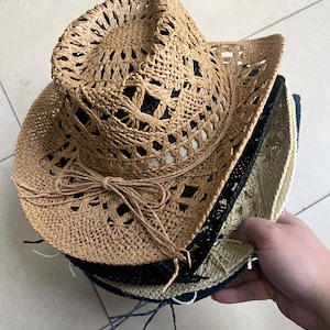Peut inclure: Un ensemble de trois chapeaux de paille, le chapeau du dessus est brun avec un motif tissé et un ruban brun noué en un nœud. Le chapeau du milieu est noir et le chapeau du bas est beige.