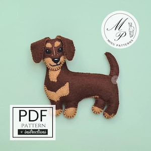 May include: A handmade felt dachshund dog in shades of brown and tan, with a smiling expression. The dog has a long body, short legs, and floppy ears. The image includes a PDF pattern with instructions and a logo.