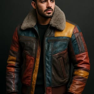 Puede incluir: Una chaqueta de cuero marrón con un diseño de patchwork en varios colores, incluyendo azul, amarillo y rojo. La chaqueta tiene un cuello de piel y una cremallera.