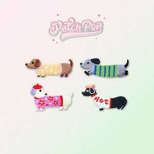 Puede incluir: Cuatro parches bordados para planchar con diseños de perros salchicha que llevan diferentes atuendos. Los perros llevan un suéter amarillo con lunares blancos, un suéter verde con rayas blancas, un suéter rosa con flores blancas y un suéter blanco con la palabra "Hot" en rojo.