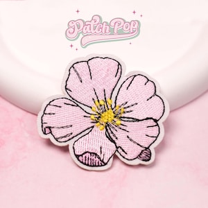 Może przedstawiać: Zestaw trzech ceramicznych kubków z nakrapianym, matowym wykończeniem. Kubki są w odcieniach kremu, jasnoszarym i ciemnoszarym. Każdy kubek ma prosty, nowoczesny design i zaokrąglony uchwyt.