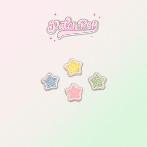 Op de afbeelding: Vier geborduurde stervormige patches in verschillende kleuren: geel, blauw, roze en groen. De patches bevinden zich op een witte achtergrond met de tekst "Patch Pop" in een retro-lettertype.
