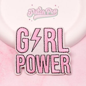 Puede incluir: Parche bordado rosa con las palabras "GIRL POWER" y un rayo en lugar de la "I", contorneado en negro. El parche está sobre un fondo blanco con un borde rosa. La marca "Patch Pop" está en la parte superior.