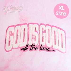 Può includere: Una toppa ricamata rosa e bianca con la scritta "GOD IS GOOD" in un font in stile universitario, con "all the time" sotto in corsivo nero. La toppa è di taglia XL.