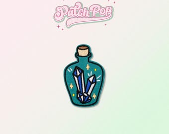 May include: A teal blue glass bottle with a cork stopper filled with blue crystals and white stars. The bottle is a patch with the text "Patch Pop" above it.