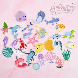 May include: A collection of embroidered patches featuring various sea creatures, including fish, a turtle, a starfish, and a lobster. The patches are in various colors, such as blue, yellow, pink, and green, with the text "Patch Pop" in a script font.