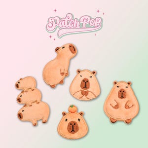 以下が含まれることがあります： さまざまなポーズをとったカピバラをモチーフにした、アイロン接着式の刺繍パッチ6個セット。パッチはベージュとブラウンで、黒い刺繍のディテールが施されています。パッチには「Patch Pop」のラベルが付いています。