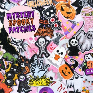 May include: A selection of Halloween patches featuring pumpkins, ghosts, skeletons, and witch hats. The patches are in orange, black, purple, and pink. The text "MYSTERY SPOOKY PATCHES" is in a pink circle. Ideal for adding to clothing or accessories.