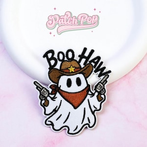 May include: An embroidered patch featuring a white ghost wearing a brown cowboy hat with a yellow star, a rust-coloured bandana, and holding two grey revolvers. The text "BOO HAW" is embroidered in black above the ghost. The logo "Patch Pop" is visible.