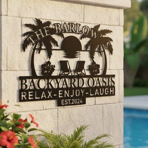 May include: A black metal sign with the words "THE BARLOWS" above "BACKYARD OASIS" and "RELAX-ENJOY-LAUGH". The sign features palm trees, a sun, two lounge chairs, and hibiscus flowers. The year "EST.2024" is also included.