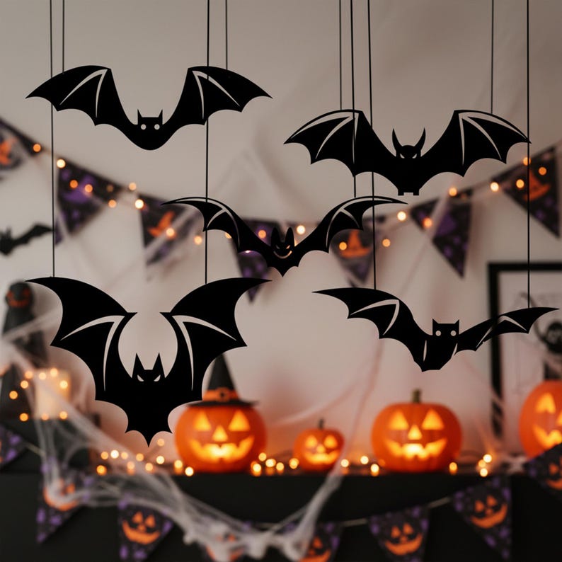Pu&ograve; includere: Decorazioni a forma di pipistrello nero appese a fili, con zucche intagliate e luci a catena sullo sfondo. I pipistrelli hanno dettagliate ali e sono sospesi davanti a decorazioni a tema Halloween, creando un'atmosfera spettrale.