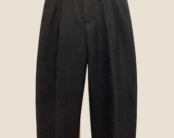 Könnte beinhalten: Dunkelgraue Hose in Anthrazit mit hoher Taille, einem einzelnen Knopfverschluss, Gürtelschlaufen und einer Vorderseite mit Falten. Die Hose hat einen geraden Schnitt, der sich nach unten hin leicht verjüngt und mit Umschlägen endet.