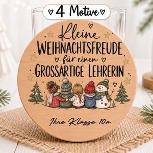 Könnte beinhalten: Eine runde Holzscheibe mit dem deutschen Text "Kleine WEIHNACHTSFREUDE für einen GROSSARTIGE LEHRERIN" und "Ihre Klasse 10a". Das Motiv zeigt vier Kinder und einen Schneemann, zwei Tannenbäume, Sterne und kleine Herzen.