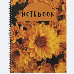 Peut inclure: Cahier à spirales avec une couverture ornée d'un motif floral. La couverture présente un gros plan de chrysanthèmes jaunes et oranges, avec le mot "NOTEBOOK" en noir en haut.