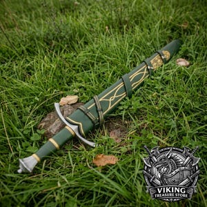 May include: A green leather-wrapped sword with a matching scabbard featuring gold-colored decorative line patterns. The sword has a silver-toned metal crossguard and a pommel, with leather straps securing the scabbard in a fixed position.
