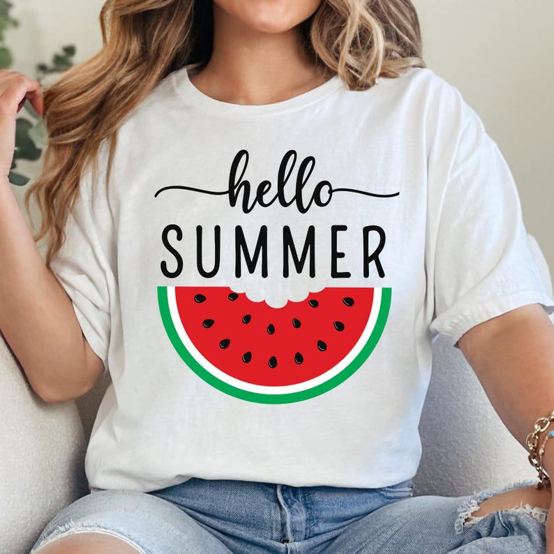 Peut inclure: T-shirt blanc avec l'inscription "hello SUMMER" en noir et un motif de past&egrave;que. La past&egrave;que est rouge avec des graines noires et une peau verte. Un haut d'&eacute;t&eacute; d&eacute;contract&eacute;.