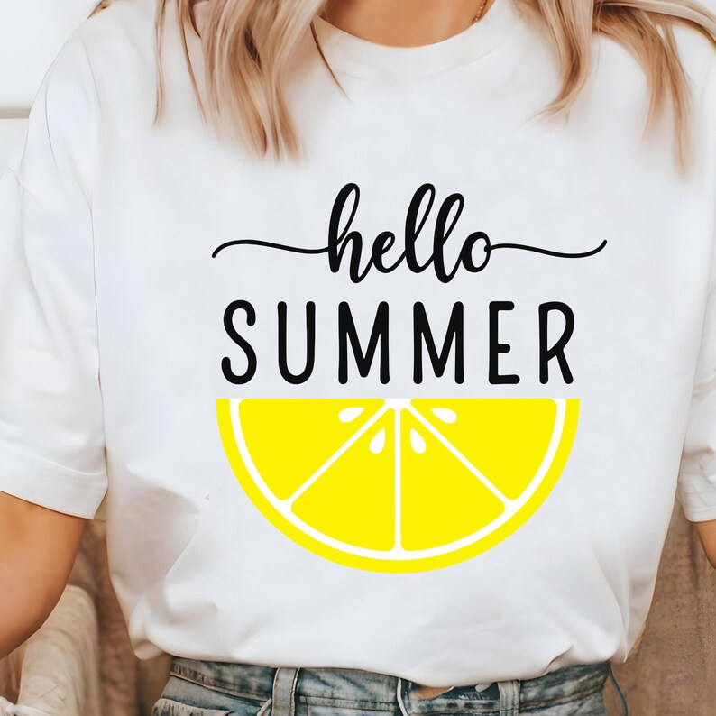 Peut inclure: T-shirt blanc avec l'inscription "hello SUMMER" en lettres cursives et majuscules noires. Un motif de tranche de citron jaune est en dessous du texte. Le t-shirt est en mati&egrave;re souple.