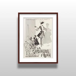 May include: Framed vintage poster in black and white, featuring a theatrical performance advertisement. The poster showcases a costumed figure with puppets and the text "LE CHEVALIER D'ÉON". The poster is framed in a dark brown wooden frame.