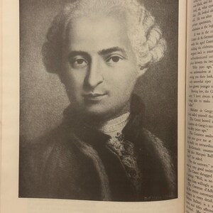May include: A monochrome portrait of Le Comte de St. Germain, from a copper engraving by N. Thomas. The image depicts a man with a powdered wig and a serious expression. The text below reads: From a copper engraving.