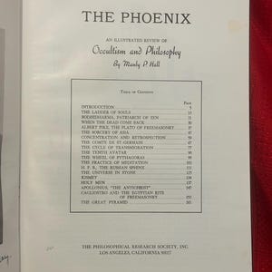 May include: An open book displaying the title "THE PHOENIX" and the subtitle "An Illustrated Review of Occultism and Philosophy" by Manly P. Hall. The table of contents includes chapters such as "The Ladder of Souls".