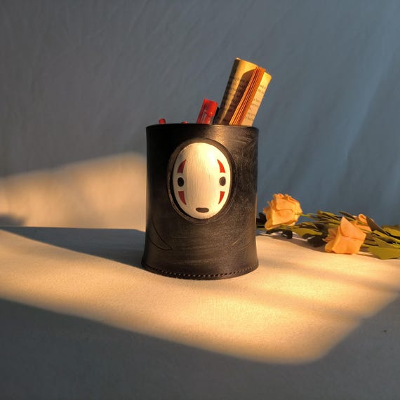 A leather-crafted No-Face (Kaonashi) pen holder — someone actually hand-stitched a Studio Ghibli spirit into functional desk art.