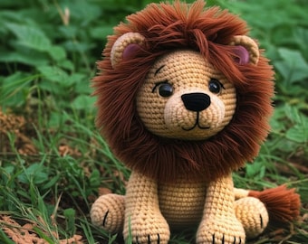 May include: A crocheted lion toy with a tan body, brown mane, and a black nose. The lion has a friendly expression with large, dark eyes. The toy is sitting in green grass, giving it a natural look.